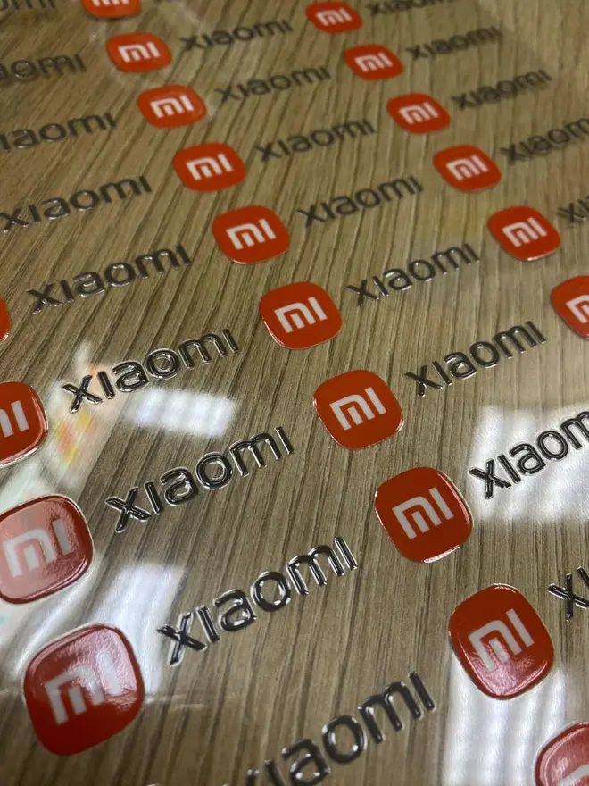 UV DTF наклейки Xiaomi на плёнке — рельефные глянцевые логотипы, готовые к переносу на технику